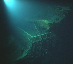 Researchers visiting deep wrecks need to bring everything – including their own light. In this haunting image, Titanic's bow is a stage for shadows and twisted steel. (Courtesy of NOAA/IFE/URI)